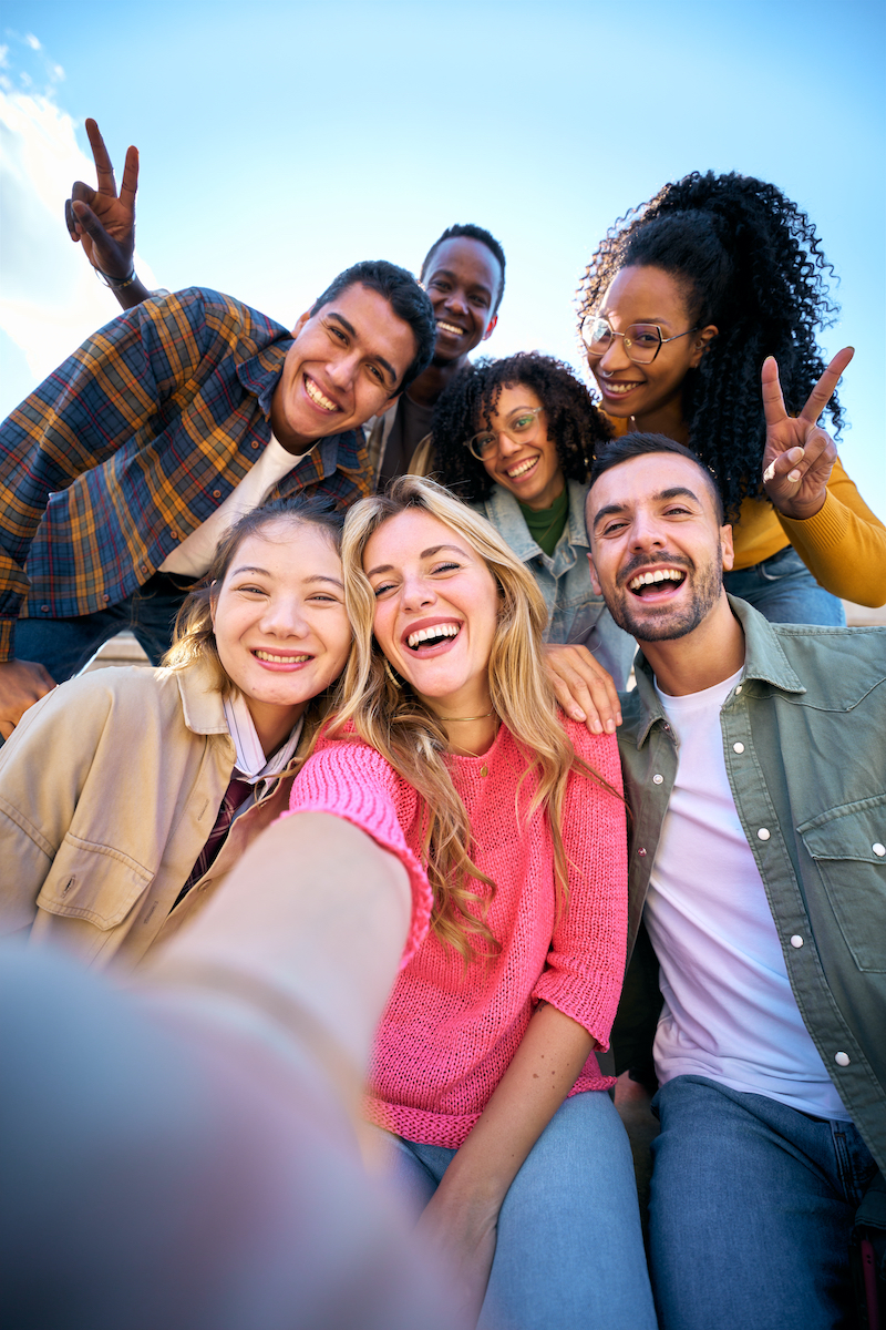 Group of multiethnic friends taking selfie with smart mobile phone outdoors